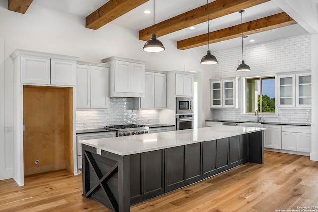 kitchen with appliances with stainless steel finishes, light hardwood / wood-style flooring, beamed ceiling, white cabinets, and hanging light fixtures