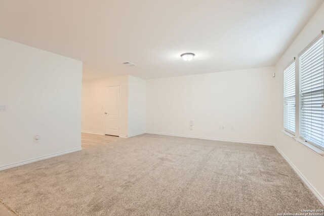 unfurnished room with light carpet