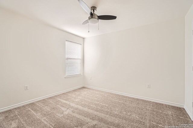 unfurnished room featuring ceiling fan and carpet floors