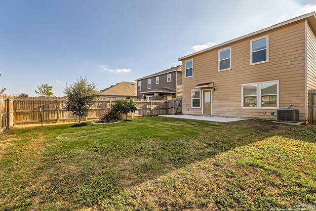 back of property with cooling unit, a yard, and a patio