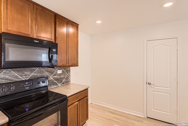 kitchen featuring tasteful backsplash, black appliances, and light hardwood / wood-style floors