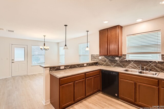 kitchen featuring dishwasher, sink, hanging light fixtures, kitchen peninsula, and light wood-type flooring