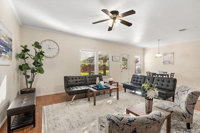 living room with ceiling fan, wood-type flooring, and ornamental molding