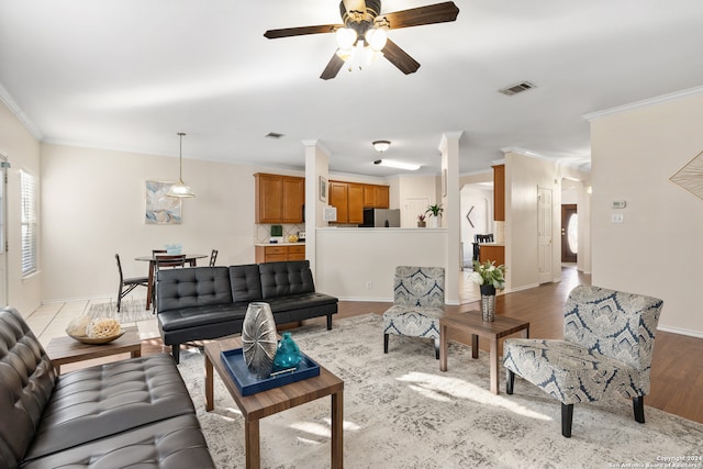 living room featuring ceiling fan, light wood-type flooring, and ornamental molding