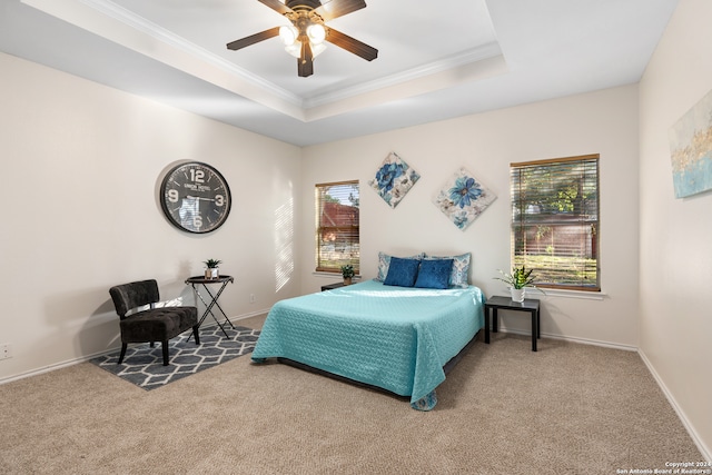 bedroom featuring ceiling fan, a raised ceiling, carpet floors, and ornamental molding