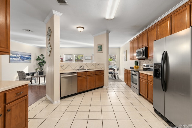 kitchen with decorative backsplash, appliances with stainless steel finishes, light tile patterned floors, and ornamental molding