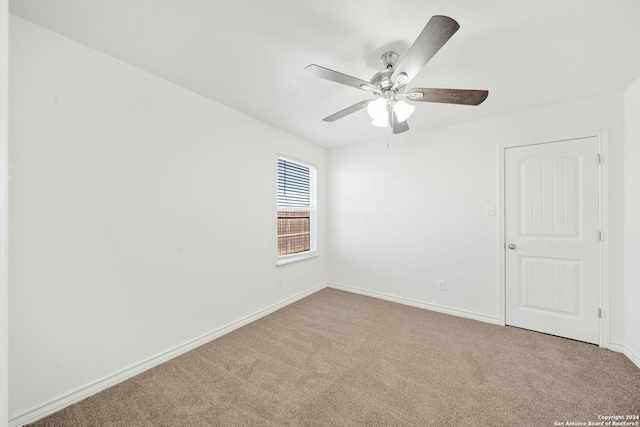 carpeted spare room with ceiling fan