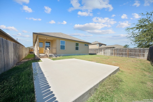 rear view of property featuring a lawn and a patio