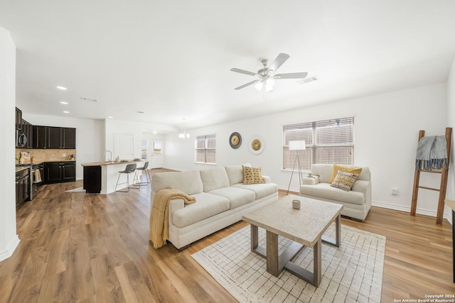 living room featuring light hardwood / wood-style floors, ceiling fan, and sink