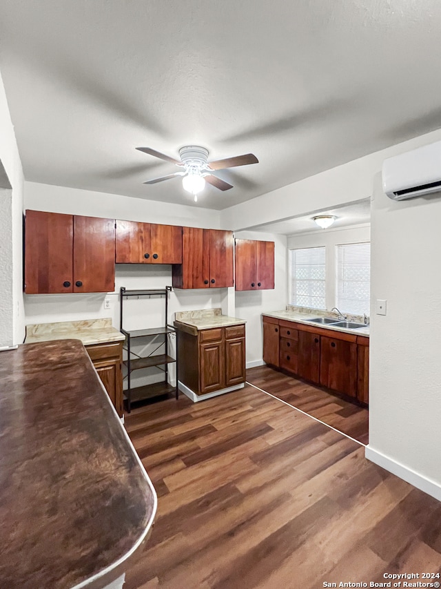 kitchen with a wall unit AC, ceiling fan, dark hardwood / wood-style flooring, and sink