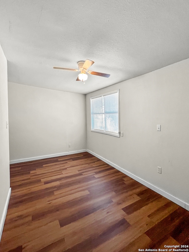 empty room featuring a textured ceiling, ceiling fan, and dark hardwood / wood-style floors