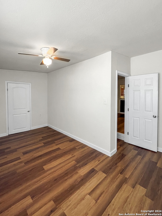 unfurnished room with dark hardwood / wood-style floors, ceiling fan, and a textured ceiling