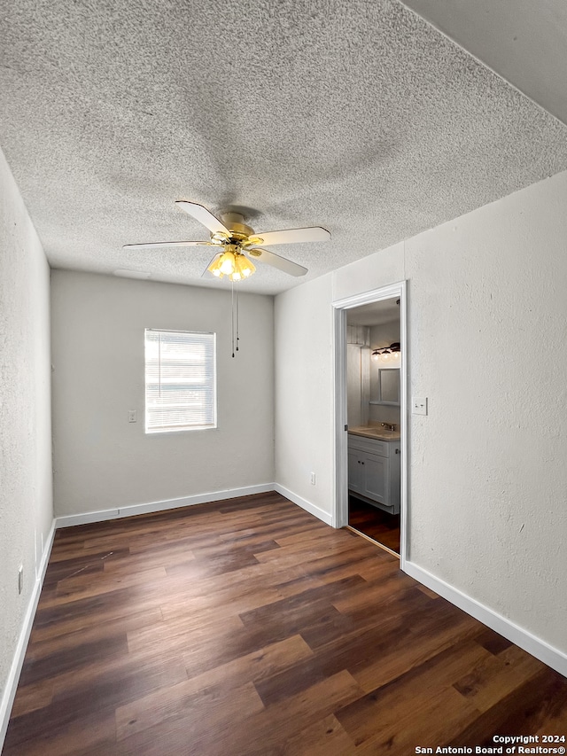 spare room with dark hardwood / wood-style floors, ceiling fan, and a textured ceiling