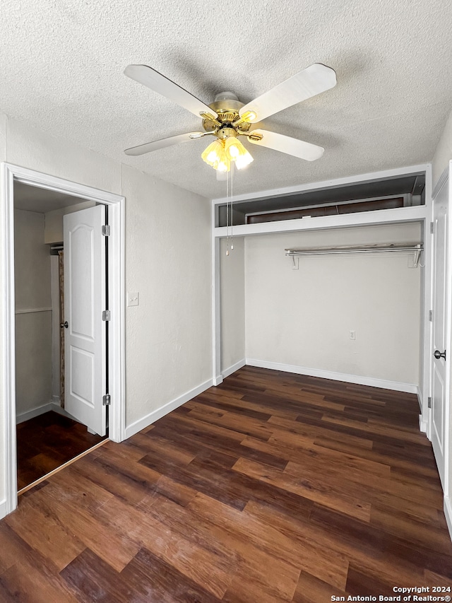 unfurnished bedroom with a textured ceiling, dark hardwood / wood-style flooring, a closet, and ceiling fan