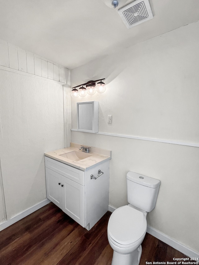 bathroom featuring vanity, wood-type flooring, and toilet