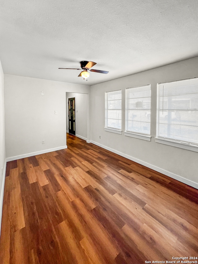 unfurnished room featuring a textured ceiling, hardwood / wood-style flooring, and ceiling fan