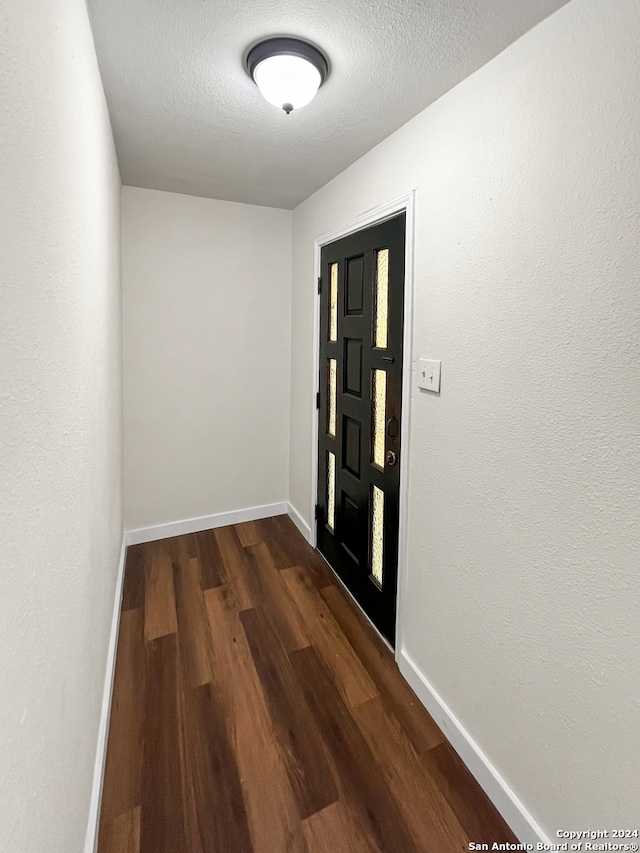 doorway to outside featuring dark hardwood / wood-style flooring and a textured ceiling