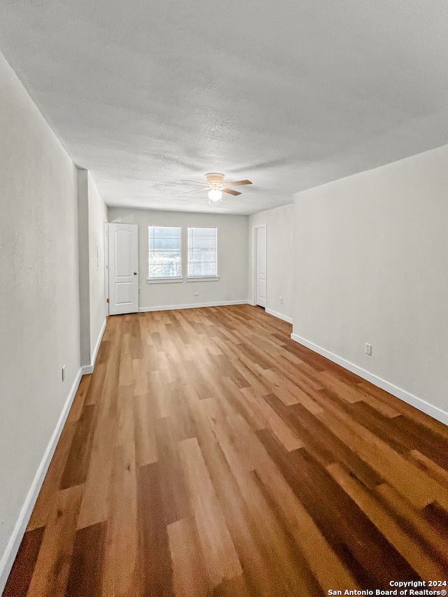 unfurnished living room with ceiling fan and light wood-type flooring