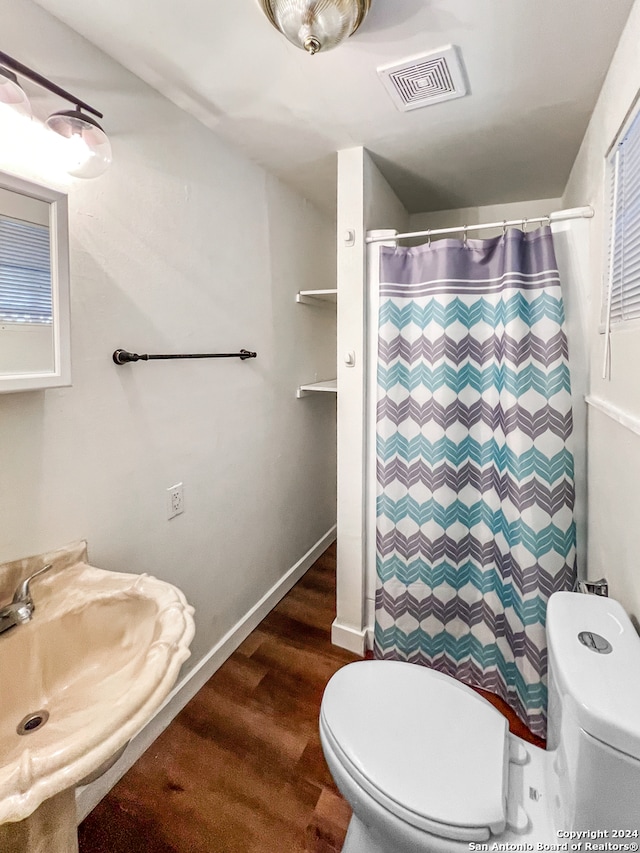 bathroom with curtained shower, toilet, sink, and hardwood / wood-style flooring