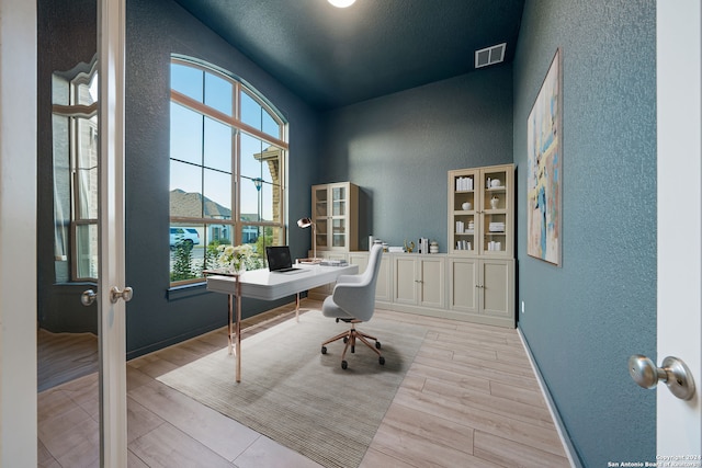 office featuring light wood-type flooring, french doors, and vaulted ceiling