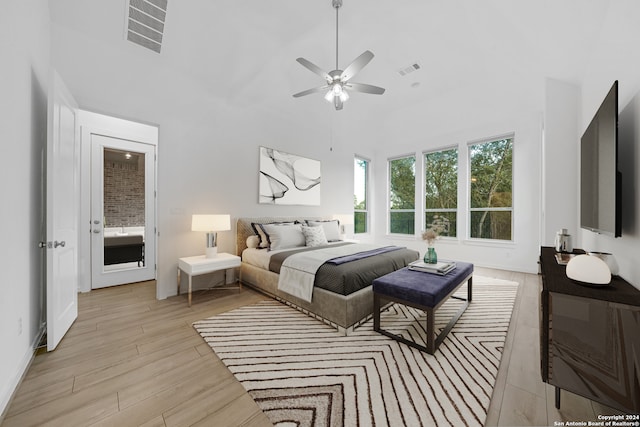 bedroom with ceiling fan, a high ceiling, and light wood-type flooring