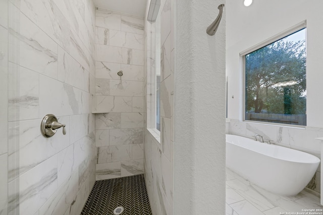 bathroom with tile walls and independent shower and bath