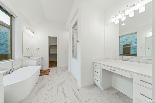 bathroom with vanity, a bathtub, and lofted ceiling