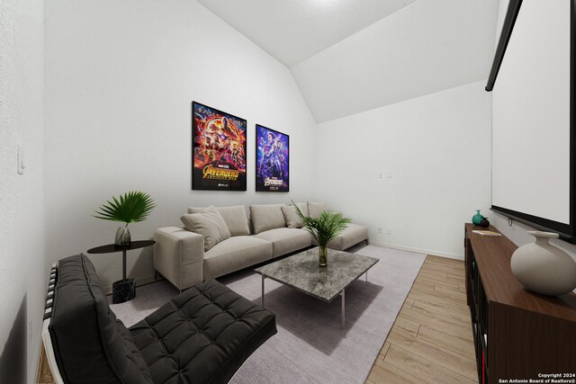 living room with vaulted ceiling and light wood-type flooring