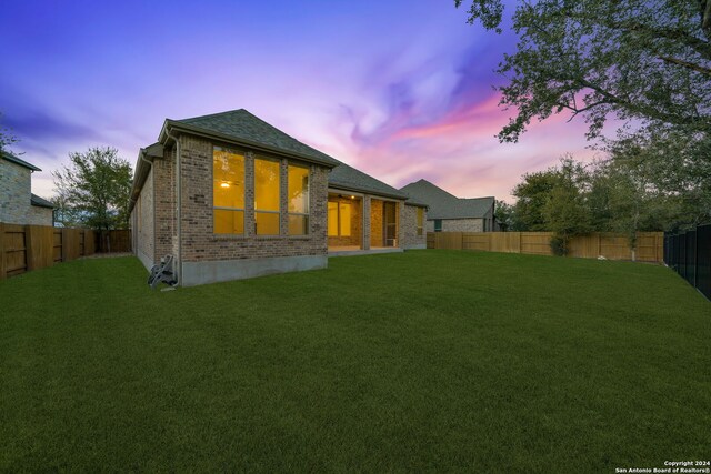 back house at dusk with a yard