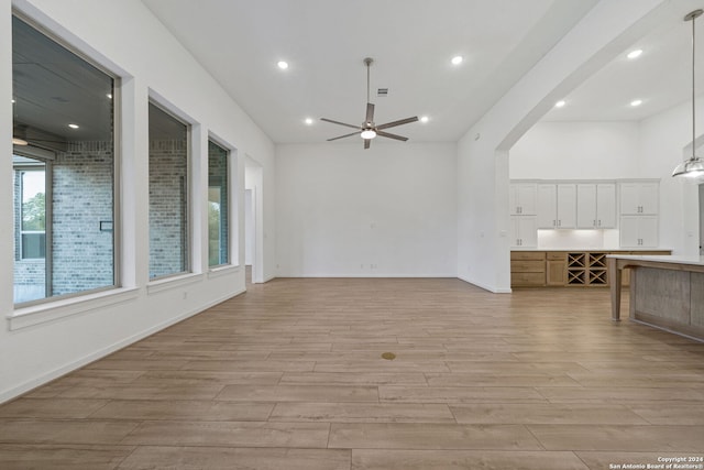 unfurnished living room featuring ceiling fan and light hardwood / wood-style flooring