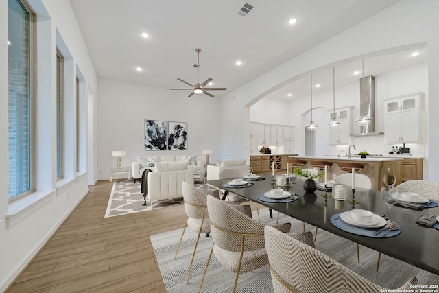 dining space featuring ceiling fan, light hardwood / wood-style flooring, and sink