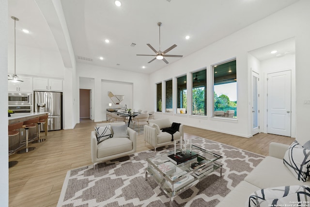 living room featuring light hardwood / wood-style flooring and ceiling fan