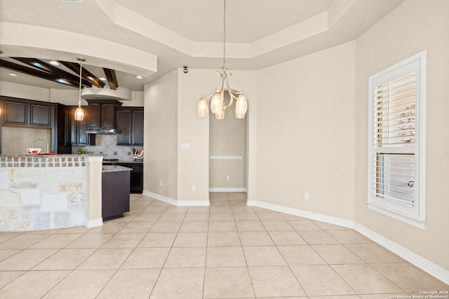 kitchen featuring a chandelier, dark brown cabinets, backsplash, and hanging light fixtures