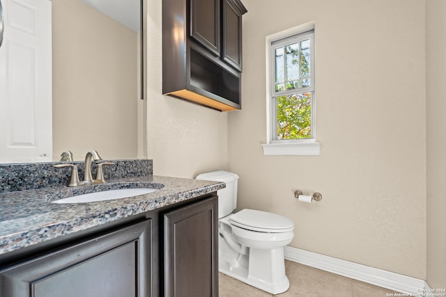 bathroom with tile patterned flooring, vanity, and toilet