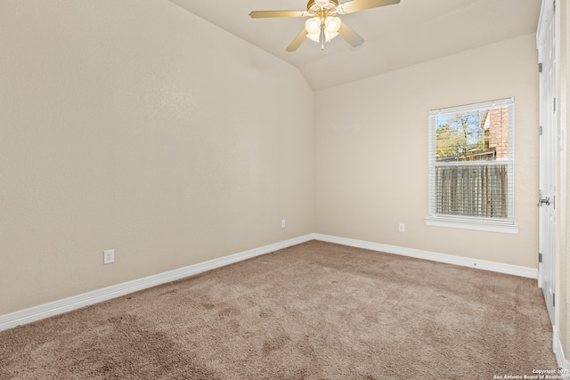 carpeted spare room with ceiling fan and vaulted ceiling