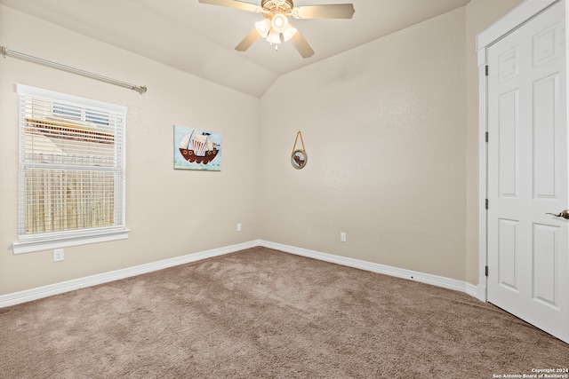 carpeted empty room with ceiling fan and vaulted ceiling