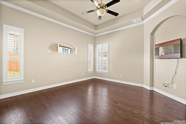 unfurnished room featuring ceiling fan, dark hardwood / wood-style flooring, crown molding, and a tray ceiling