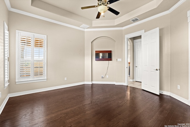 spare room with hardwood / wood-style flooring, ceiling fan, a raised ceiling, and ornamental molding