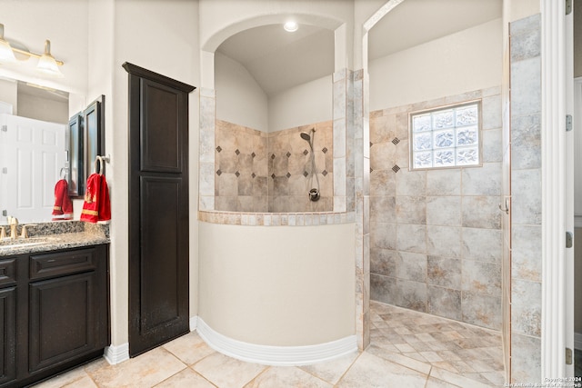 bathroom featuring tile patterned floors, vanity, and a tile shower