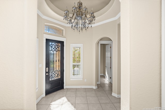 entryway featuring a tray ceiling, a towering ceiling, and light tile patterned flooring