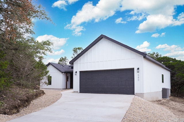 modern farmhouse style home featuring central AC unit and a garage