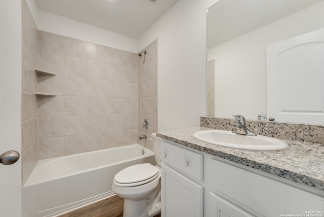 full bathroom with vanity, toilet, tiled shower / bath, and hardwood / wood-style flooring