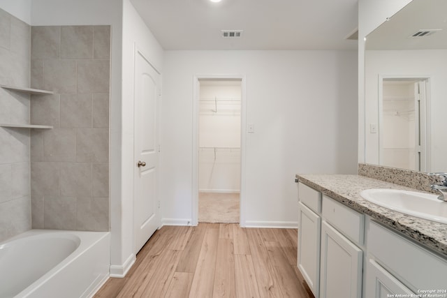 bathroom featuring a bathing tub, vanity, and hardwood / wood-style flooring