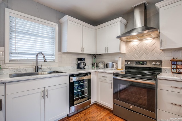 6531 Fox Run, San Antonio, TX 78233 - kitchen with wall chimney range hood, electric stove, beverage cooler, and white cabinets