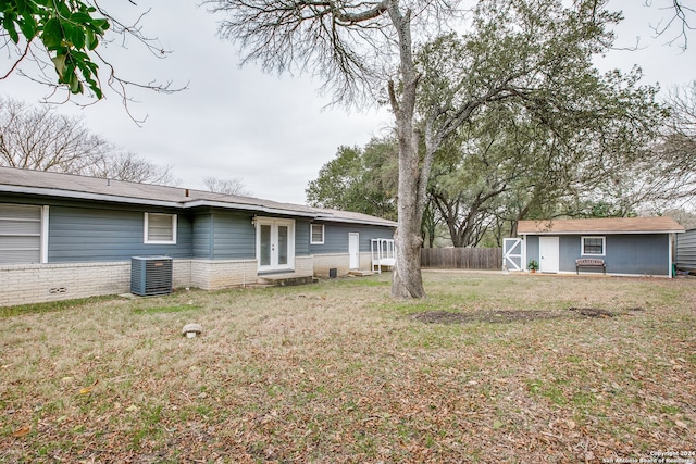 view of yard featuring an outbuilding, cooling unit, and french doors