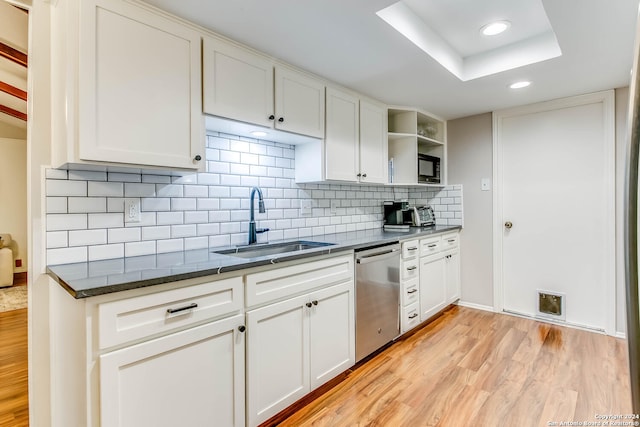 kitchen featuring white cabinets, light hardwood / wood-style floors, and stainless steel dishwasher