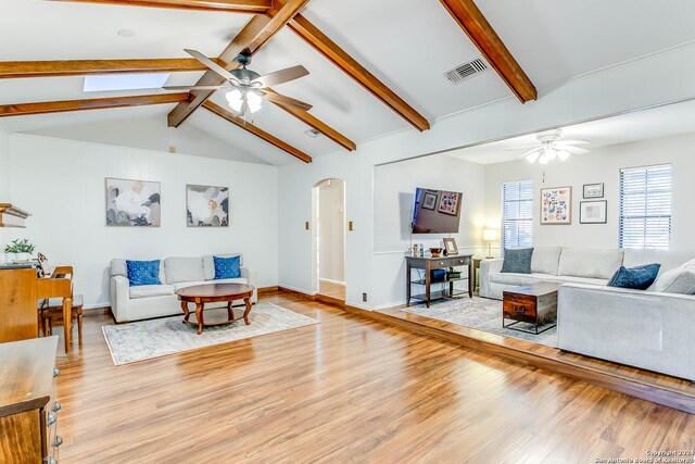 living room with lofted ceiling with beams, light hardwood / wood-style floors, and ceiling fan