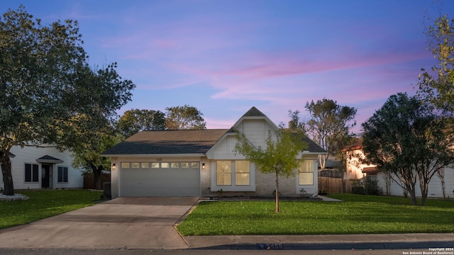 view of front of property with a garage and a yard