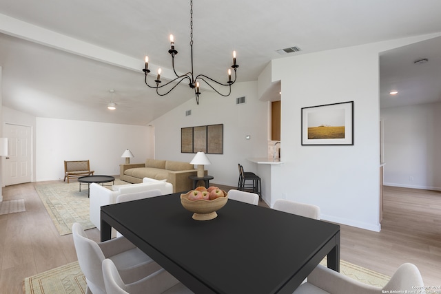 dining space featuring ceiling fan with notable chandelier, light hardwood / wood-style flooring, and lofted ceiling