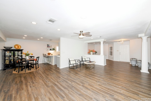 living room with hardwood / wood-style flooring, ceiling fan, and ornate columns